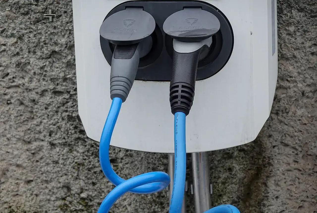 Elektroauto lädt an einer Wallbox vor einem Wohnhaus